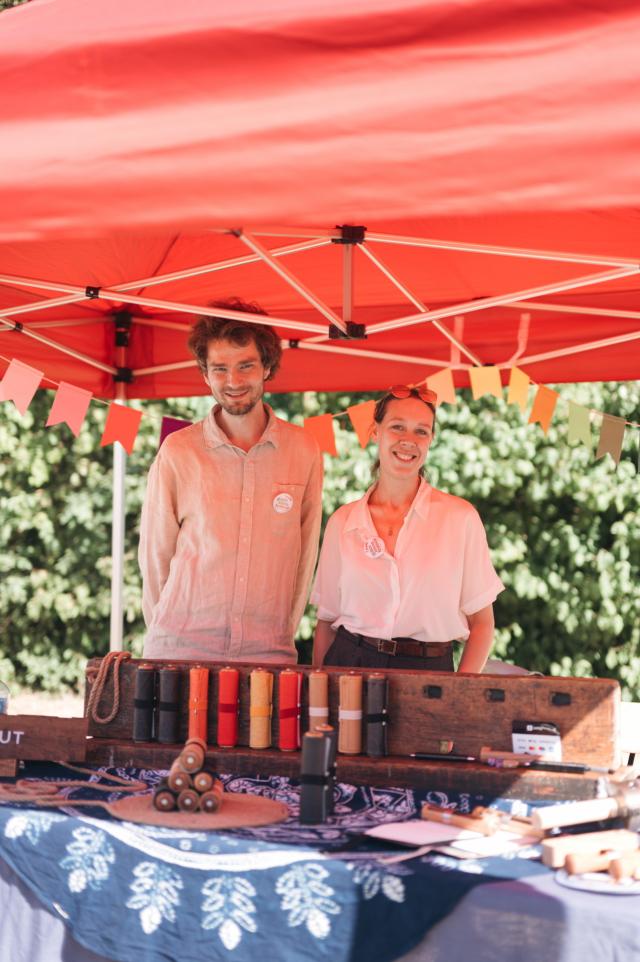 Thomas and Sa standing behind the Rollgut stand on Gutes Klima Festival 