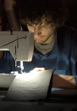 Thomas sitting on the sewing machine, making a Wrap