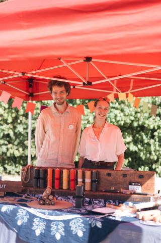 Thomas and Sa standing behind the Rollgut stand on Gutes Klima Festival 