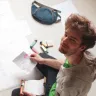 Rollgut Founder Thomas Sommer sitting on the floor, surrounded with papers and writing utensils, engaged in creative work using Rollgut